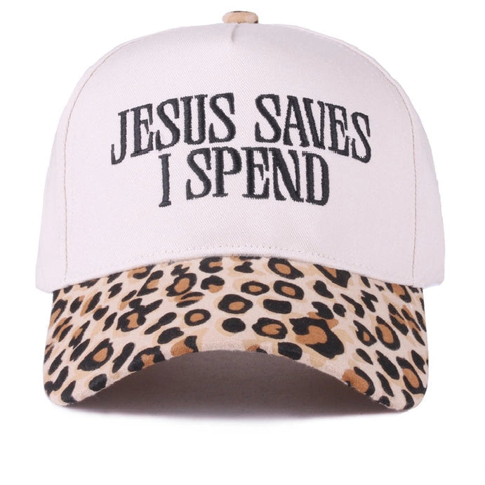 A baseball cap with a light pink crown and a leopard print visor, featuring the text 'JESUS SAVES I SPEND' embroidered in black on the front. The word 'LEOPARD' is printed in black in the bottom right corner.